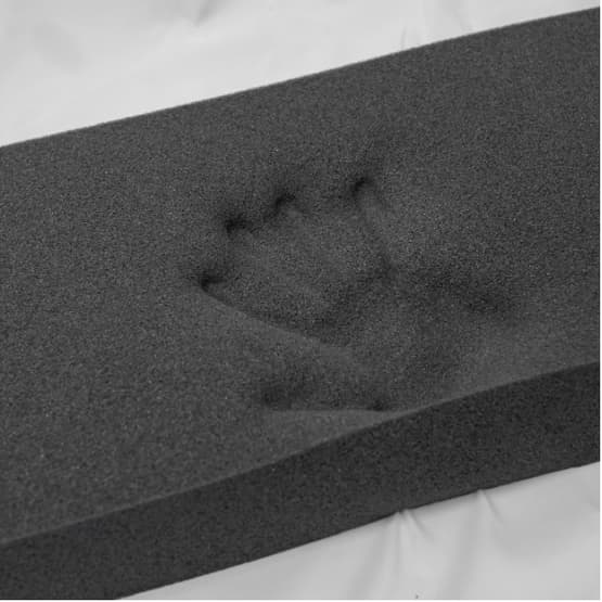 Memory foam piece with hand print showing responsiveness
