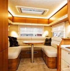 White booth cushions surrounding table in RV